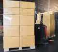 Cargo boxes shipment, Manufacturing and warehousing. Stack of cardboard boxes on pallet and forklift pallet jack in the warehouse Royalty Free Stock Photo