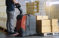 Cargo boxes shipment, Worker working with electric forklift pallet jack unloading cardboard boxes on pallet in the warehouse. Royalty Free Stock Photo