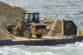 Cargo of bucket loader and sand on barge on Acushnet River