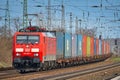 Cargo class locomotive with colorful wagons passing through Saarmund, Germany