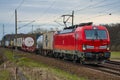 Cargo class locomotive with colorful wagons passing through Saarmund, Germany