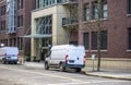 Cargo commercial mini vans standing on the urban city street with multilevel buildings