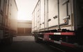 Cargo Container Trucks Parked at Distribution Warehouse with the Sunset. Shipping Trucks. Cargo Freight Trucks Transport Logistics
