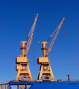 Cargo cranes in the port of Bremerhaven with a blue sky.