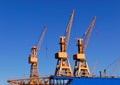 Cargo cranes in the port of Bremerhaven with a blue sky.