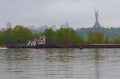 Cargo delivery by river transport. The tug boat towing a barge with sand. The Motherland monument in the background Royalty Free Stock Photo