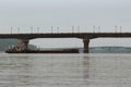 Cargo delivery by river transport. The tug boat towing a barge with sand. Paton Bridge and Metro Bridge in the background Royalty Free Stock Photo