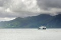 Cargo ferry in tropical sea under monsoon storm heavy clouds and tropical Koh Chang island on horizon in Thailand