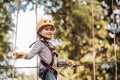 Cargo net climbing and hanging log. Cute school child boy enjoying a sunny day in a climbing adventure activity park Royalty Free Stock Photo