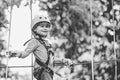 Cargo net climbing and hanging log. Cute school child boy enjoying a sunny day in a climbing adventure activity park Royalty Free Stock Photo