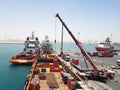 Cargo operations ongoing onboard supply vessel working for offshore platforms. Oil and Gas industry with vessels in background