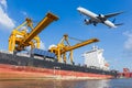 Cargo plane flying above ship port with working crane loading Royalty Free Stock Photo