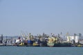 Cargo port with port cranes. Sea bay and mountainous coast.