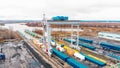 Cargo river port - A big industrial crane unloading the cargo from the freight carriages on the ground