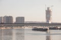 Cargo ship, a barge, under stari savski most bridge on sava river with construction of Belgrade waterfront, or Beograd na vodi.