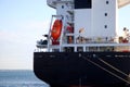 Cargo ship close up. Freight ship with orange lifeboat. Royalty Free Stock Photo