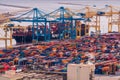 Aerial view of a bustling container port in Barcelona, with a variety of containers, cranes.