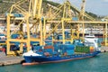 Cargo ship docked at container terminal with yellow cranes Royalty Free Stock Photo
