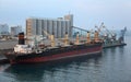 Cargo ship docked to industrial port Royalty Free Stock Photo