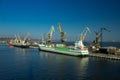 Cargo ship docking at seaport for transshipment. Cranes load containers for international trade. Maritime transport