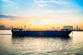 Cargo ship and dry bulk vessel at sunset. Export or import in Asia. Grain or wheat transportation. Royalty Free Stock Photo