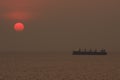 Cargo ship floating in the sea while the sunset, Silhouette sunset Royalty Free Stock Photo