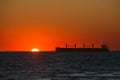 Cargo ship floats on the ocean at sunset time Royalty Free Stock Photo