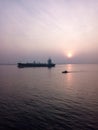 The cargo ship is greeted by the rising sun
