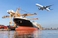 Cargo ship in the harbor and cargo plane flying above ship port Royalty Free Stock Photo