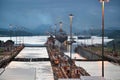 Cargo Ship Navigating Panama Canal Locks at Dusk with Illuminated Poles Royalty Free Stock Photo