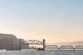 A cargo ship passes under the Oregon Trunk Rail Bridge on the Columbia River Royalty Free Stock Photo