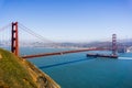 Cargo ship passing under Golden Gate Bridge on a sunny day; San Francisco skyline in the background; California Royalty Free Stock Photo