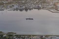 Cargo ship sailing into baltic sea at tromsdalen norway city viewed from a mountain viewpoint Royalty Free Stock Photo