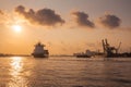 Cargo ship is sailing out of the harbor at evening to sea to transport cargo in the container Royalty Free Stock Photo