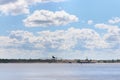 Cargo ship sails on river with coastline with sand