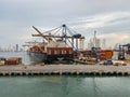 A cargo ship and shipping containers on a dock early in the morning at port in Cartagena, Columbia