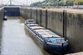 Cargo ship and small boat at Lanaye lock, between huge walls with low water level Royalty Free Stock Photo