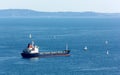 Cargo Ship Surrounded by Sailboats