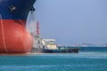 Cargo ship with tugboat assistance in sea to shipyard for maintenance Royalty Free Stock Photo