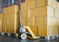 Cargo shipment boxes. Commercial warehousing. Stack of cartons product boxes and hand pallet truck at the warehouse storage. Royalty Free Stock Photo