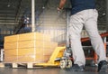 Cargo Shipment, Warehousing, Worker working with hand pallet truck unloading carton product boxes on pallet. Royalty Free Stock Photo