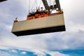 Cargo shipping container lifted by a gantry crane in a industrial shipping terminal in a port Royalty Free Stock Photo