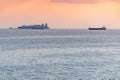 Cargo ships and barge at beautiful sunset. Amazing evening seascape, breathtaking travel view, copy space. Anchorage for ships