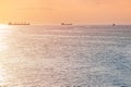 Cargo ships and barge at beautiful sunset. Amazing evening seascape, breathtaking travel view, copy space. Anchorage for ships