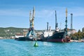 Cargo ships docked for loading in old harbor. The green buoy close-up. Royalty Free Stock Photo