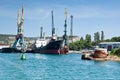 Cargo ships docked for loading in old harbor. The rusty buoy close-up. Royalty Free Stock Photo