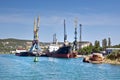 Cargo ships docked for loading in old harbor. The rusty buoy close-up. Royalty Free Stock Photo