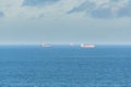 Cargo ships seen far away in the middle of the sea Royalty Free Stock Photo