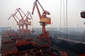 Cargo terminal for discharging coal cargos by shore cranes during foggy weather. Port Bayuquan,China. Royalty Free Stock Photo