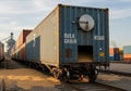 Cargo train car carrying bulk grain on railway tracks. The blue container, labeled \